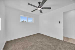 Carpeted spare room featuring ceiling fan