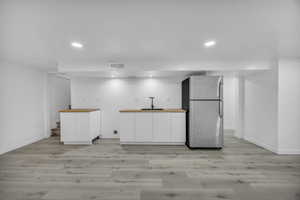 Kitchen featuring light hardwood / wood-style floors, stainless steel refrigerator, and sink