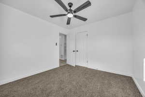 Spare room featuring ceiling fan and carpet