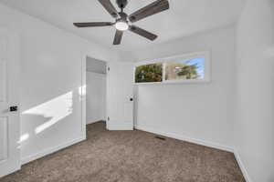 Carpeted spare room with ceiling fan