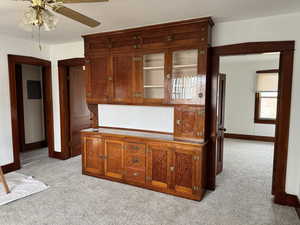 Kitchen with light colored carpet and ceiling fan