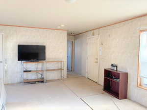 Unfurnished living room with ornamental molding