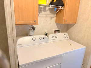 Clothes washing area with cabinets and washer and dryer