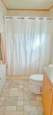 Full bathroom featuring vanity, toilet, shower / bathtub combination with curtain, and ornamental molding