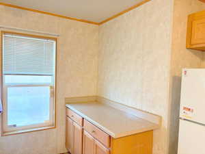 Kitchen with white refrigerator and crown molding