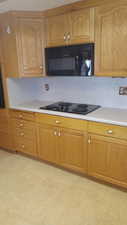 Kitchen featuring black appliances and backsplash