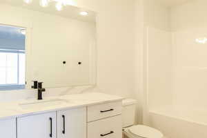 Full bathroom with vanity, tub / shower combination, and toilet