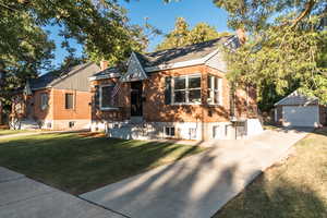 View of front facade featuring a front lawn, an outdoor structure, and a garage