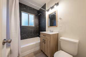 Full bathroom with wood-type flooring, vanity, toilet, and shower / tub combo with curtain