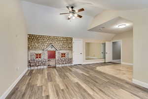 Unfurnished living room with lofted ceiling, ceiling fan, and wood-type flooring