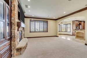 Unfurnished living room with a wealth of natural light and light carpet