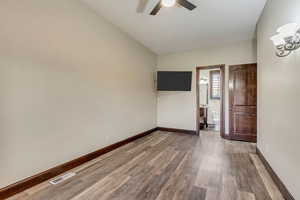 Empty room featuring hardwood / wood-style floors, ceiling fan, and vaulted ceiling