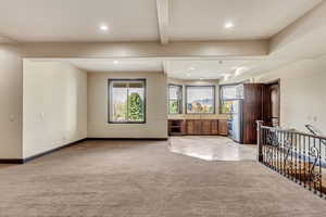 Unfurnished living room with light colored carpet and sink