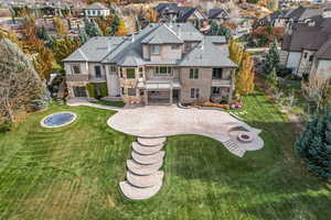 Back of house with a patio, a fire pit, and a lawn