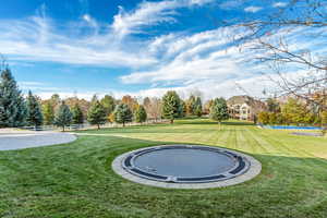 Surrounding community featuring a lawn and a trampoline