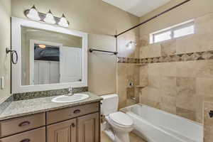 Full bathroom featuring toilet, vanity, and tiled shower / bath