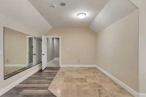 Bonus room with wood-type flooring and lofted ceiling