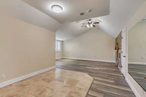 Interior space with ceiling fan, dark hardwood / wood-style flooring, and vaulted ceiling