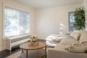 Living area featuring radiator heating unit and hardwood / wood-style floors