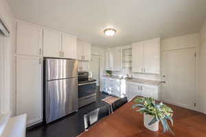 Kitchen with white cabinetry, stainless steel appliances, and tasteful backsplash