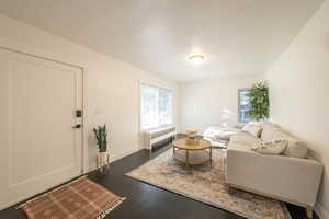 Living room with radiator and dark wood-type flooring