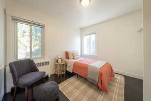 Bedroom with dark wood-type flooring and radiator