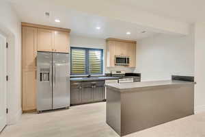 Kitchen featuring kitchen peninsula, stainless steel appliances, sink, light brown cabinets, and light hardwood / wood-style floors