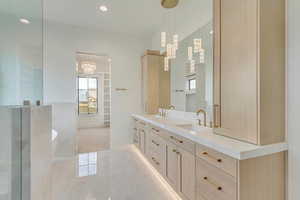 Bathroom featuring tile patterned flooring, vanity, a tub to relax in, and a notable chandelier