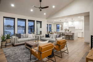 Living room featuring ceiling fan, high vaulted ceiling, and hardwood / wood-style flooring