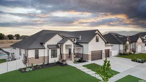 View of front of home featuring a garage and a lawn