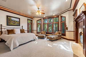 Bedroom featuring light carpet, crown molding, and ceiling fan