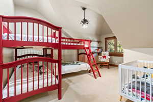 Bedroom featuring carpet and vaulted ceiling