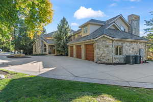 View of property exterior with central AC, a yard, and a garage