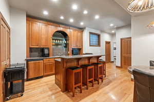 Kitchen featuring a kitchen breakfast bar, a center island, light hardwood / wood-style floors, and tasteful backsplash