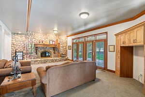 Living room featuring light carpet, crown molding, a textured ceiling, and a fireplace