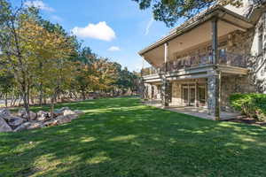 View of yard with a balcony and a patio