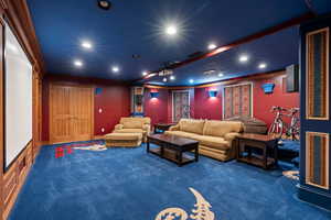 Cinema with crown molding and dark colored carpet