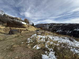 Snowy yard featuring a mountain view and a rural view