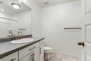 Bathroom with a shower, vanity, and toilet