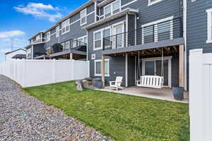 Back of house with a yard and a patio