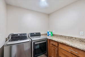 Laundry area featuring washer and dryer and cabinets