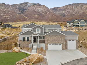 Craftsman-style home with a mountain view, a front yard, and a garage