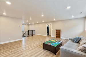 Living room featuring light wood-type flooring and a textured ceiling