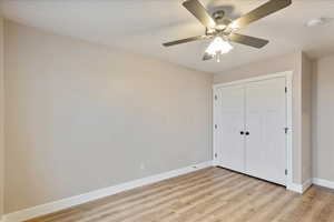 Unfurnished bedroom featuring ceiling fan, light wood-type flooring, and a closet