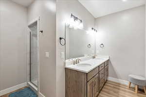 Bathroom featuring hardwood / wood-style flooring, vanity, and an enclosed shower