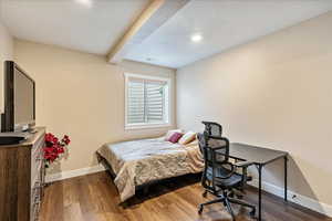 Bedroom with beam ceiling, wood-type flooring, and a textured ceiling