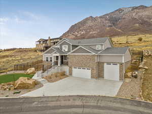 View of front of home with a mountain view and a garage