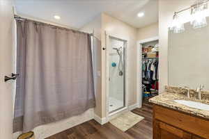 Bathroom with hardwood / wood-style flooring, vanity, and curtained shower