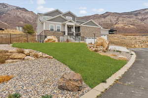 Craftsman-style house with a mountain view, a garage, and a front yard