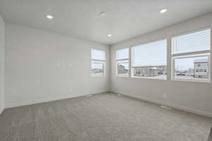 Carpeted spare room featuring a textured ceiling